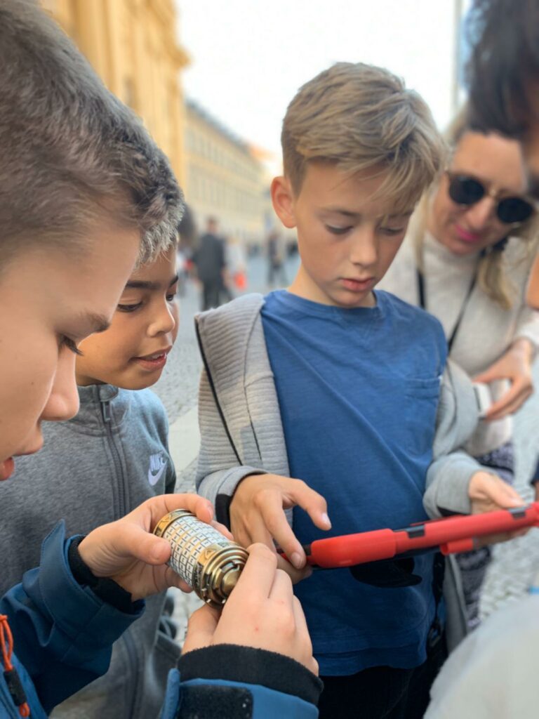 Personen am Odeonsplatz mit einer Kryptex-Gehimrolle und iPad