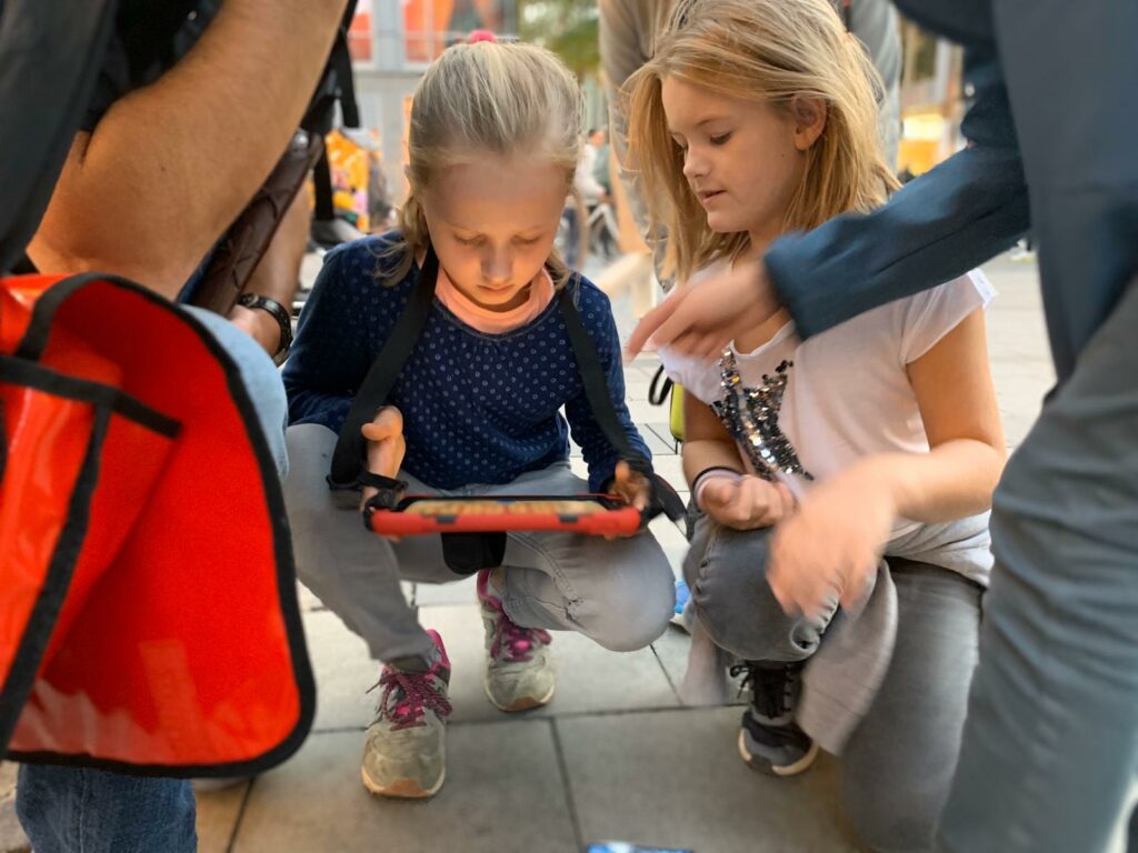 Gruppe von Kindern kniet vor iPad